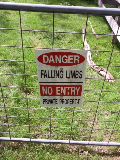 a danger sign sitting on the side of a fence