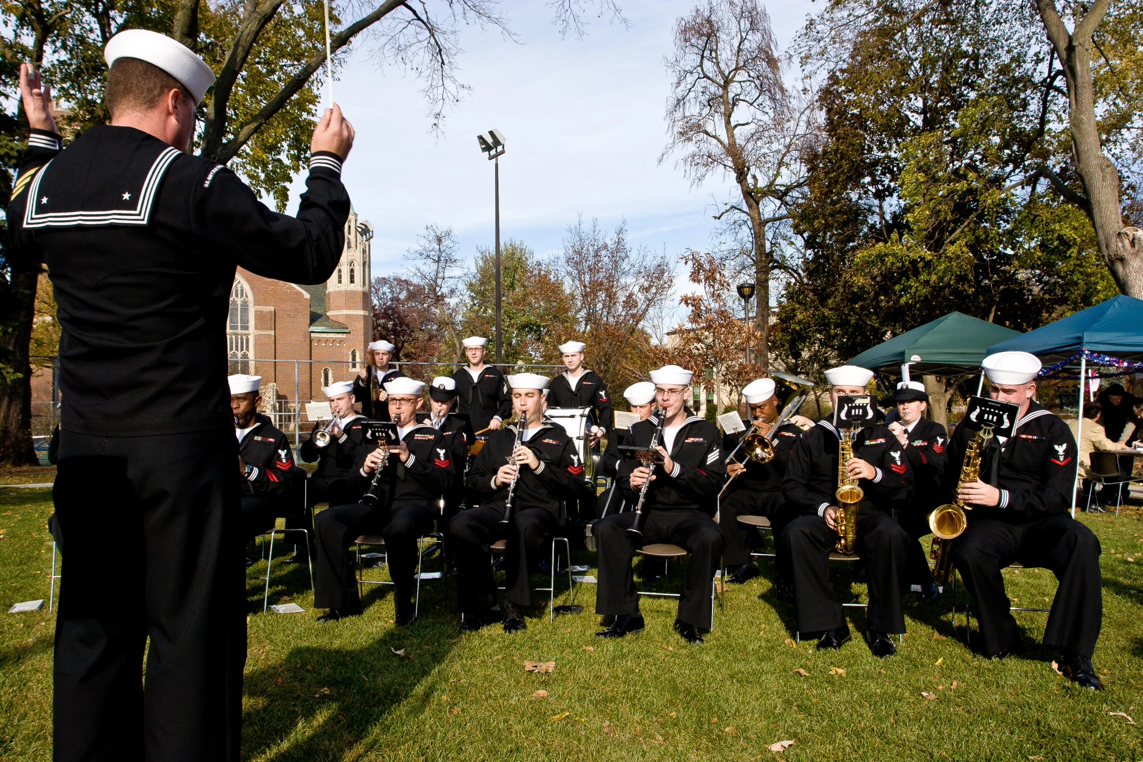 a marching band in uniform plays for spectators