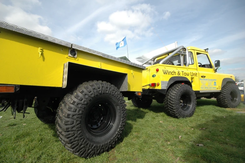 a yellow monster truck parked on top of green grass