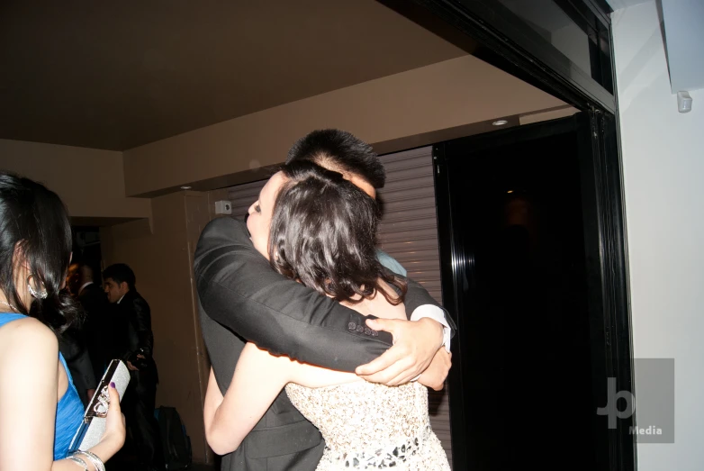 a couple hugging each other in a party