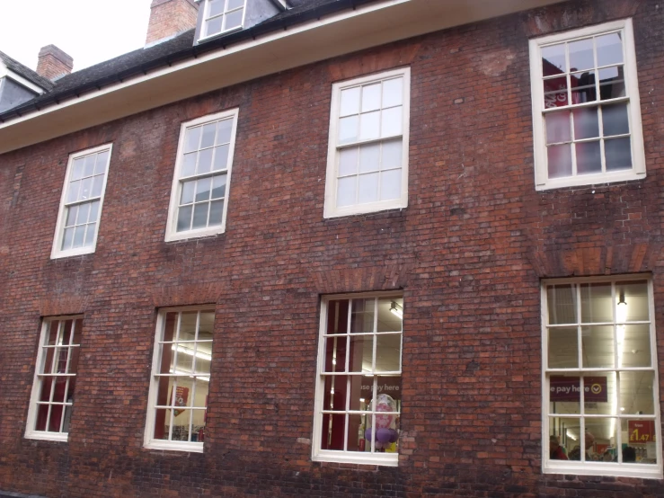 the old brick building with five windows is filled with lots of books