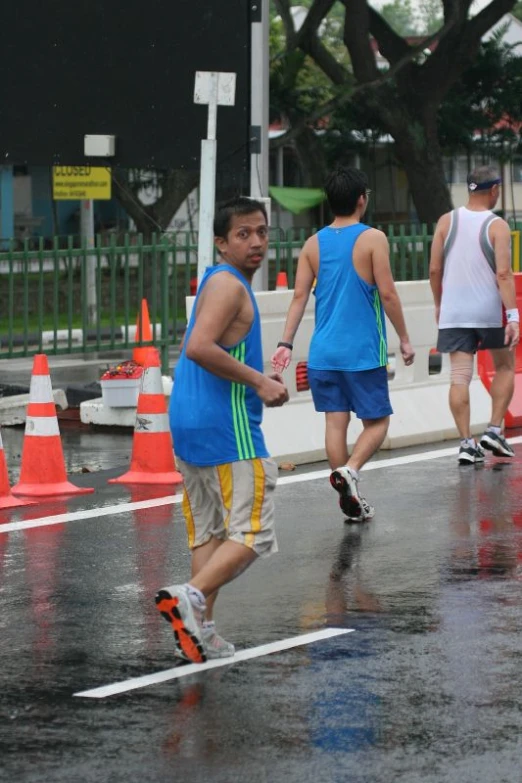 a man jogging in the rain wearing orange shoes