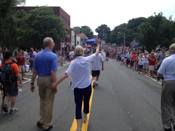 several people walking down the street in a parade