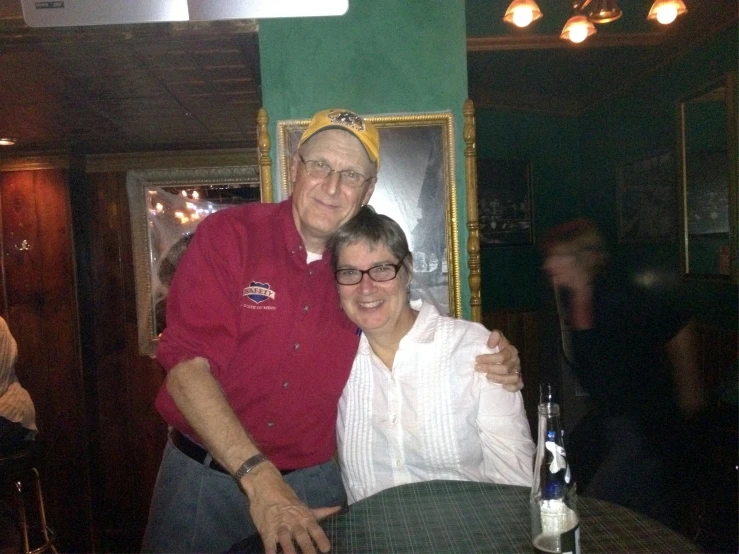 an older man and woman are posing together in a restaurant
