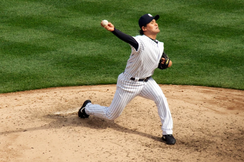 a baseball player in grey is winding up for a pitch