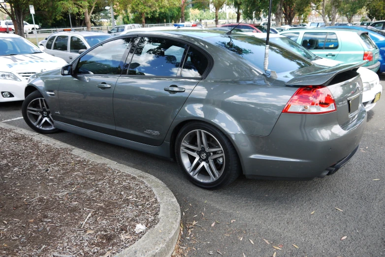 a grey sedan with its top open parked in a lot