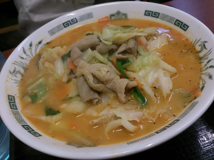 a bowl of soup with cabbage, mushrooms and carrots