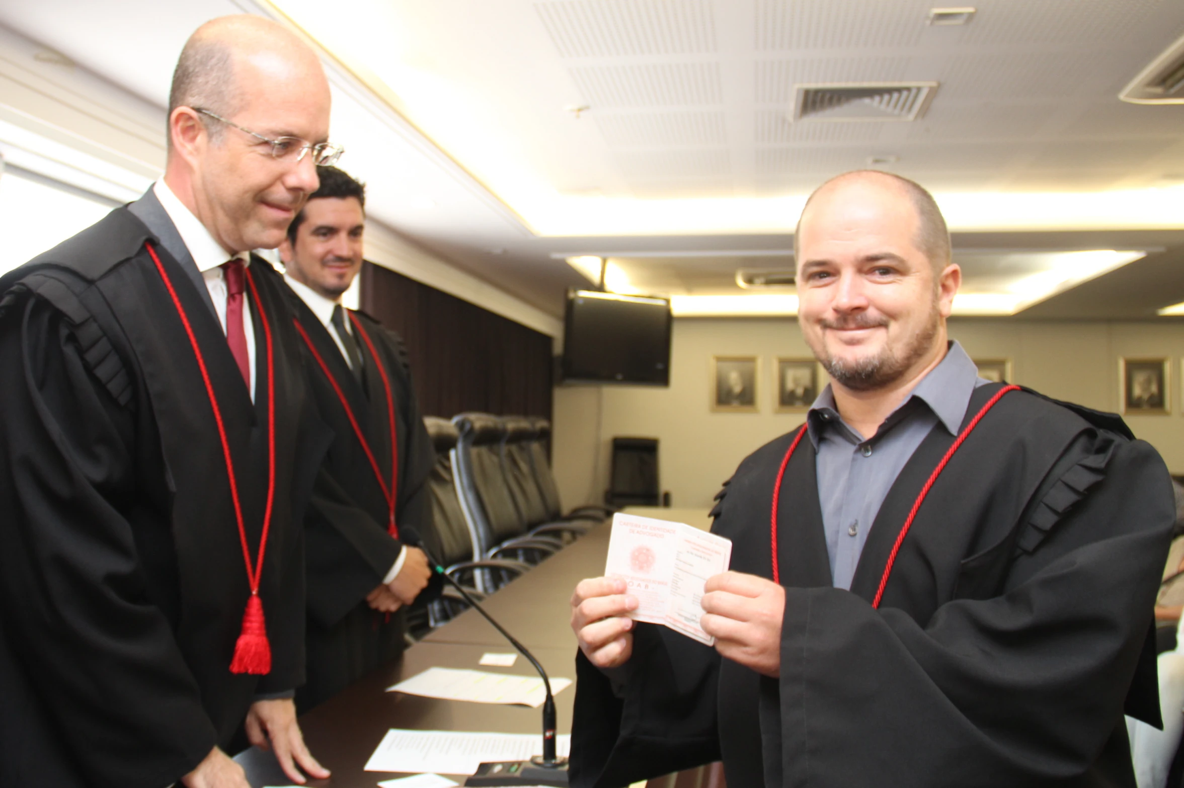 two men wearing graduation caps and gowns are playing cards