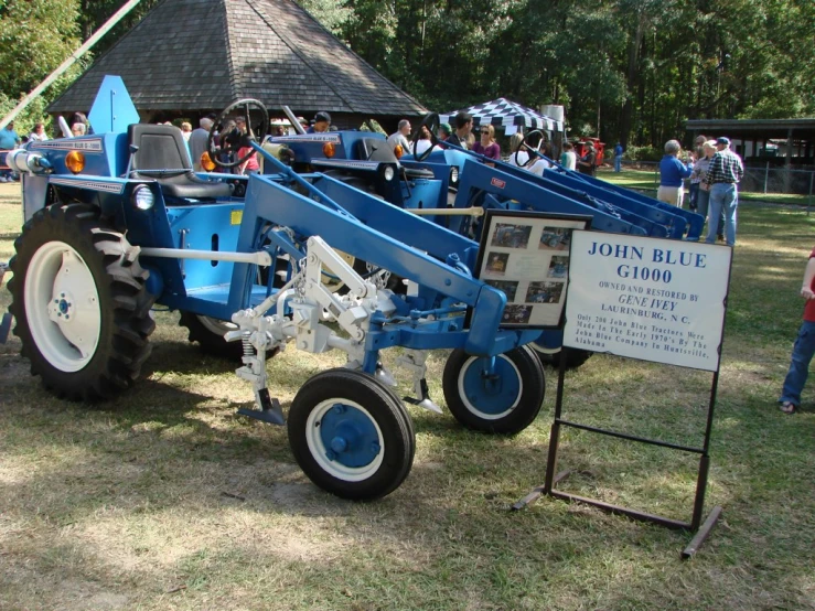 a blue tractor parked on top of a grass field