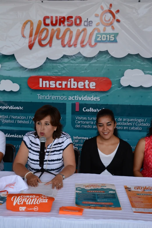 three people standing at a booth with microphone