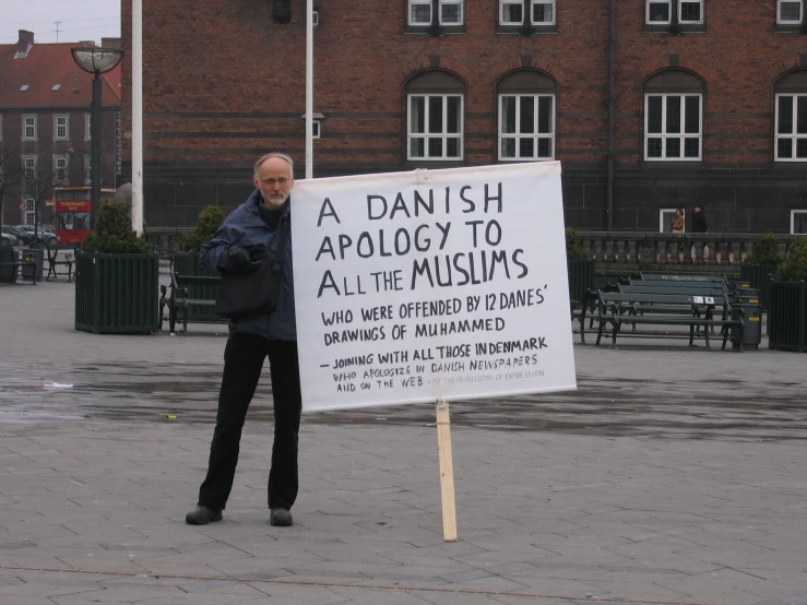 a sign with a man holding it up for a protest