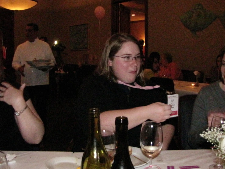 a woman at a dinner table with wine