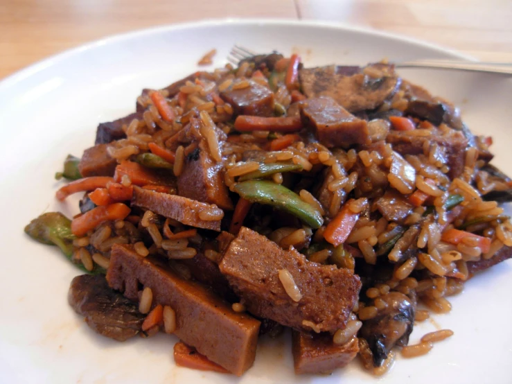 a plate of rice with meat and vegetables on it