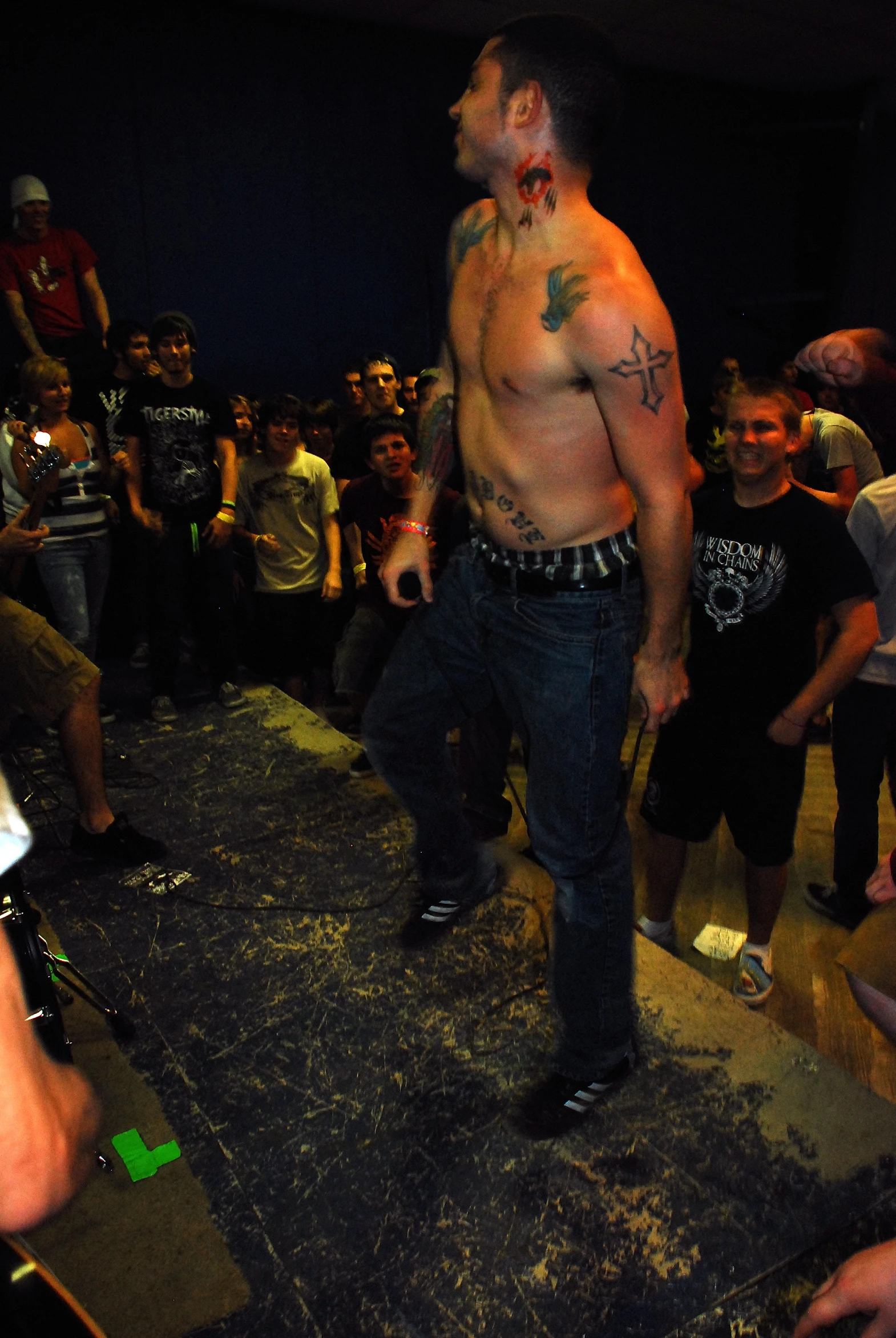 a man with tattoos standing in front of a crowd