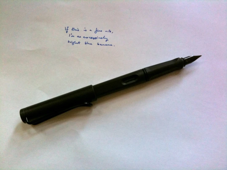 a pen writing on top of a white piece of paper