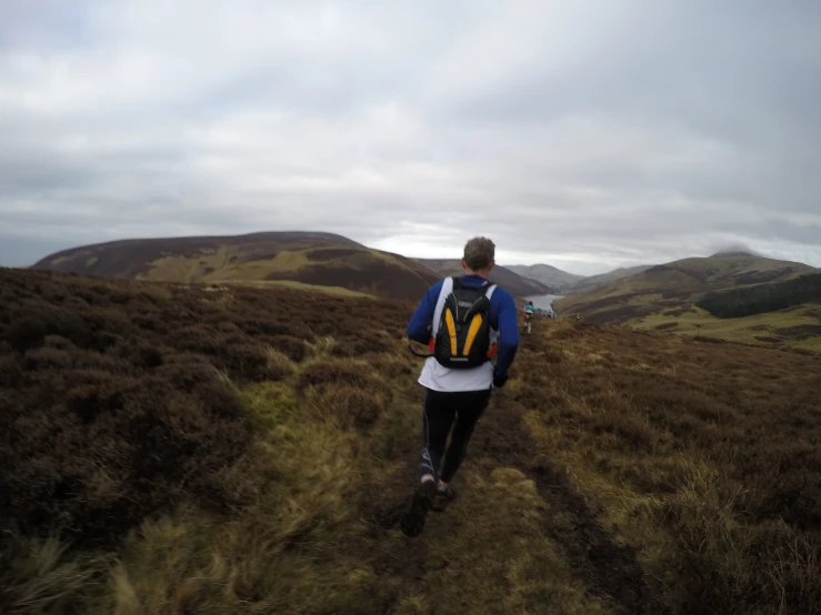 a person walking in a field of hills