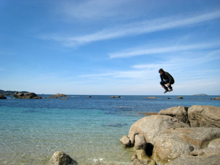 a man riding skis off the side of a rock