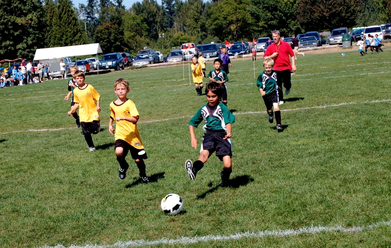 s running after a soccer ball in a grassy field