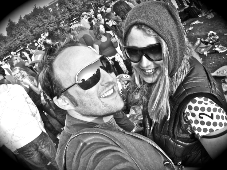 a man and woman taking a selfie at an outdoor concert