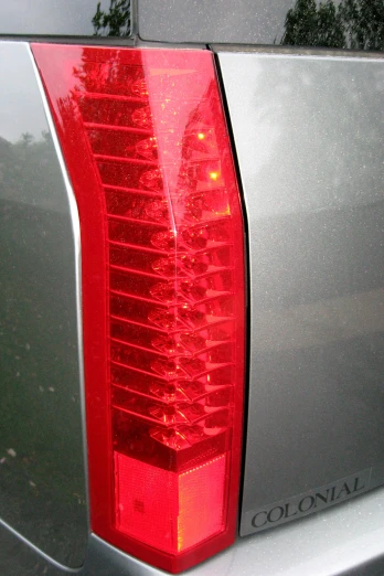 a tail light with a yellow light reflected in it