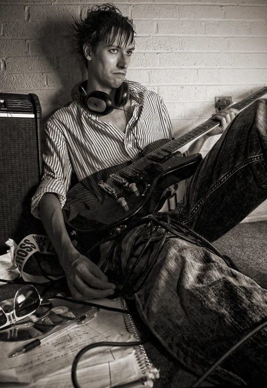 a man sitting on top of a floor wearing headphones