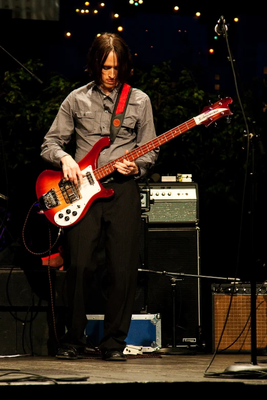 the guitarist stands on stage at an outdoor music festival