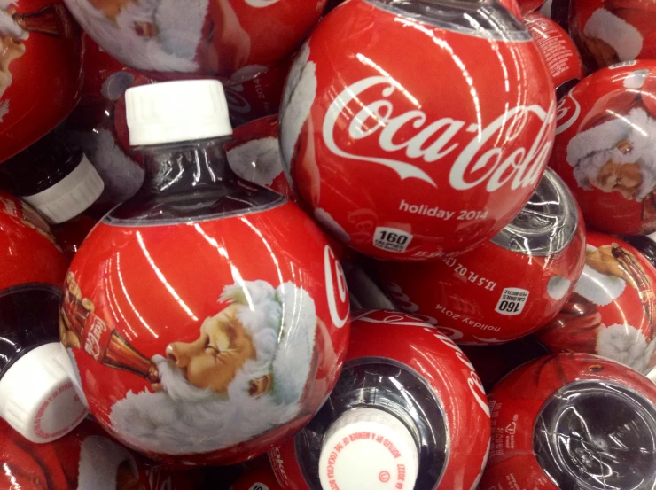 coca - cola's christmas balls are piled high in a heap