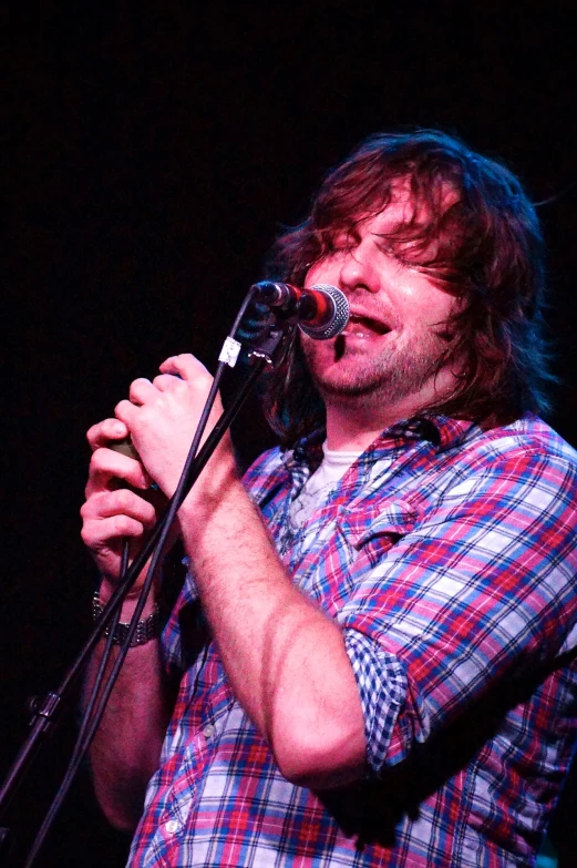 a man standing in front of a microphone on a stage