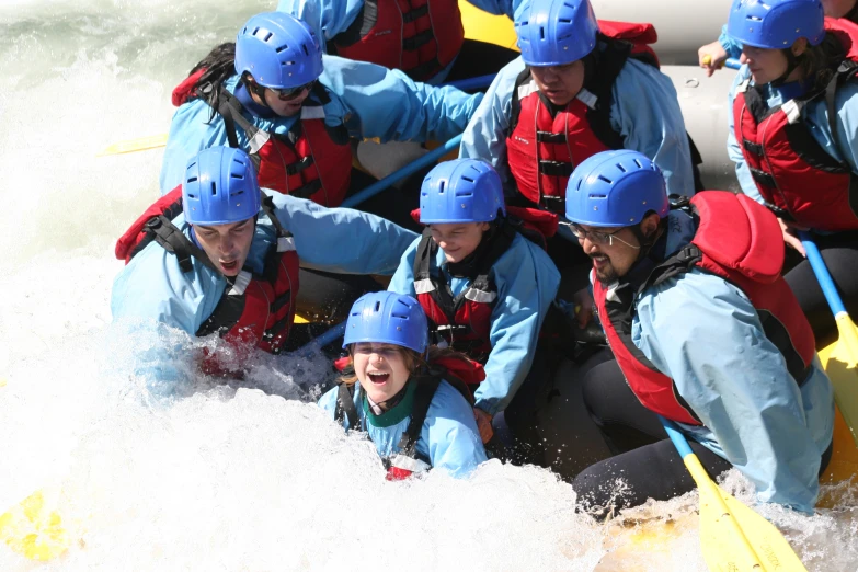 a group of people in blue helmets, white water rafters