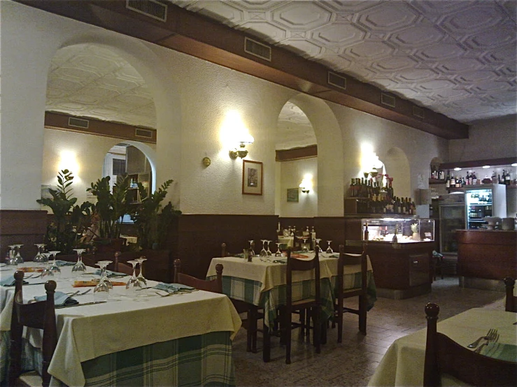 a dining room with white tablecloths and decorated ceilings
