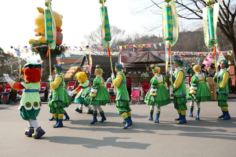 a group of people dressed in green dresses and holding flags