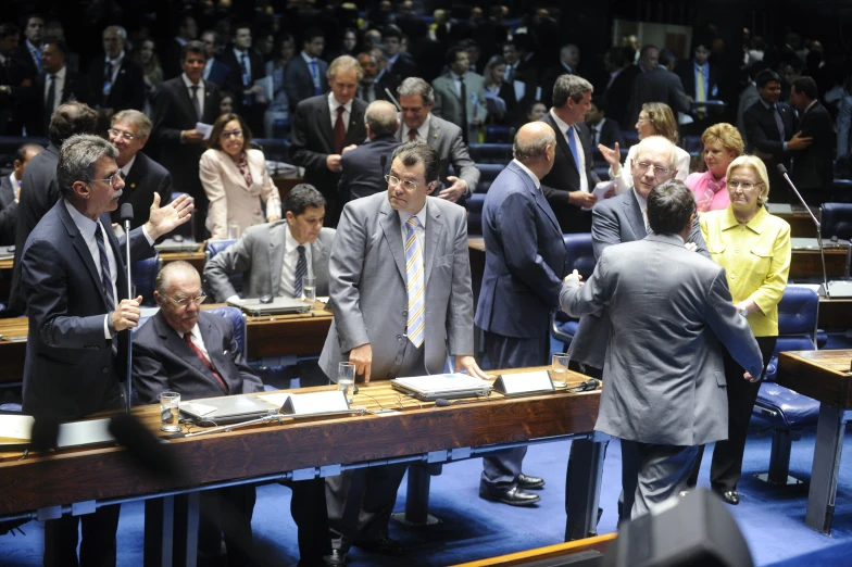 men and women in suits are shaking hands in a conference room