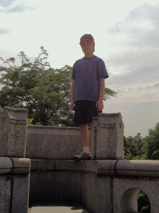 a person standing in front of a fence and tree