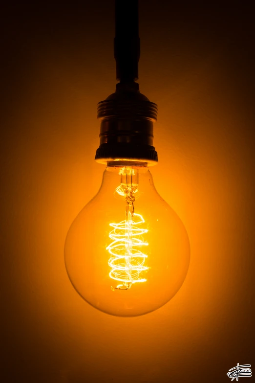 a light bulb hangs on a white wall