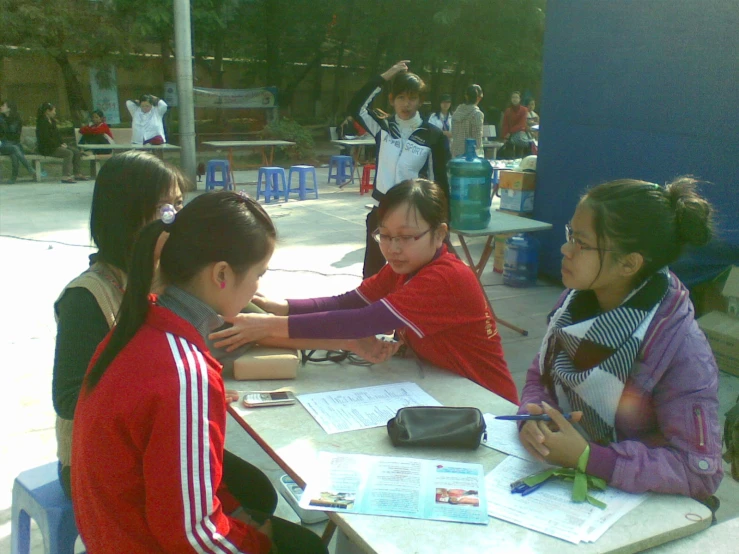 several girls sitting at a table having a conversation