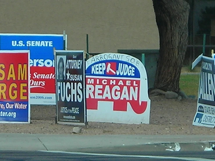 political campaign signs are leaning on each other