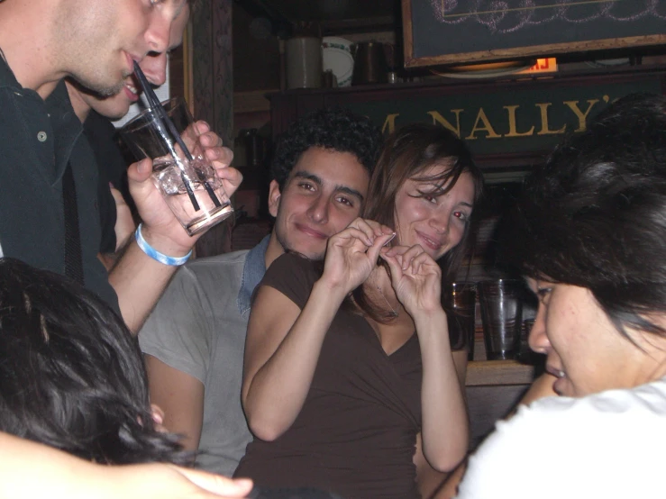 the group of young adults are drinking together at a social event