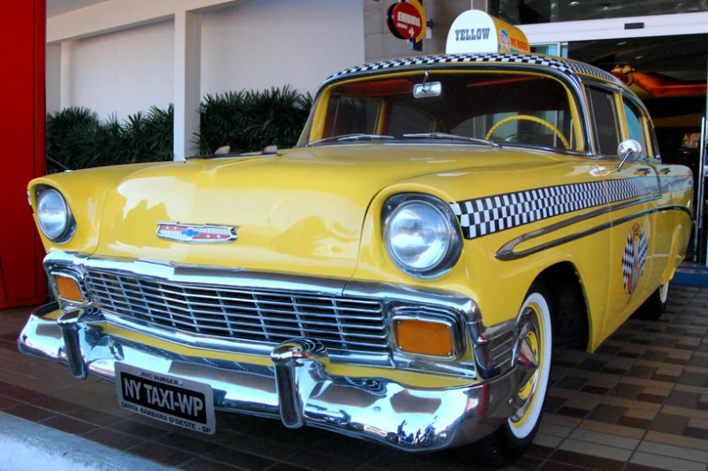 a yellow taxi sitting on the side of a street