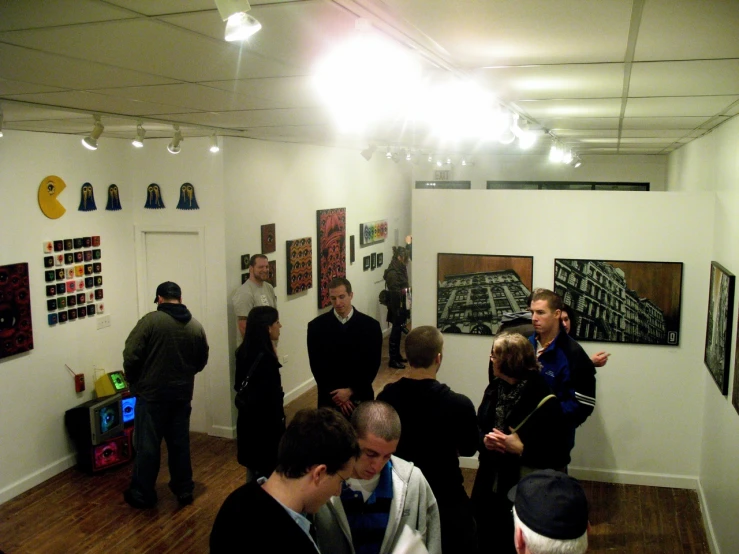 people standing in the middle of a room looking at artwork