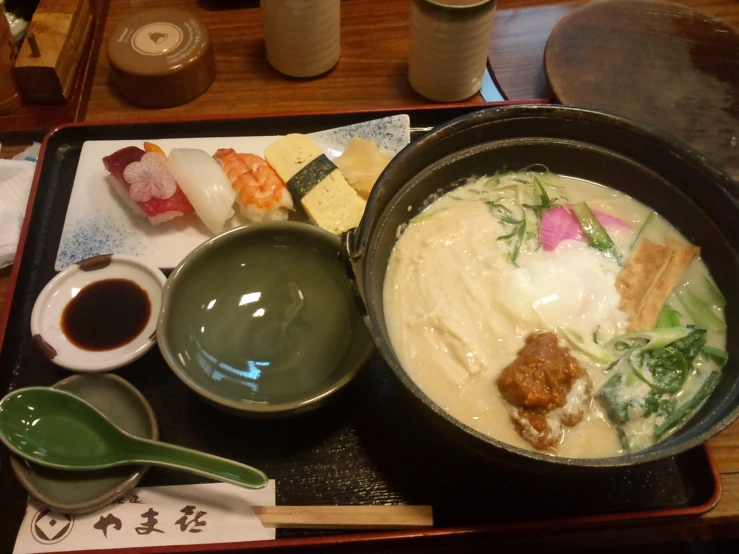 a tray of sushi and chopsticks sitting on a table