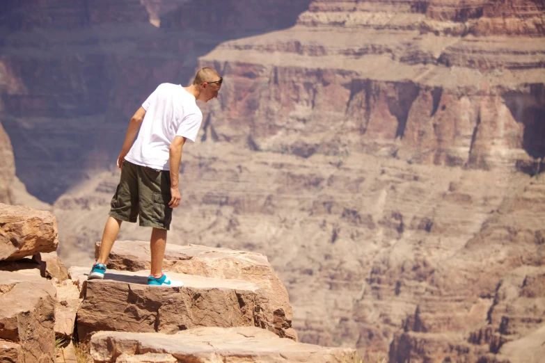 a man standing on a ledge with a skateboard