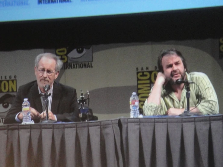 two men are sitting down and talking to each other