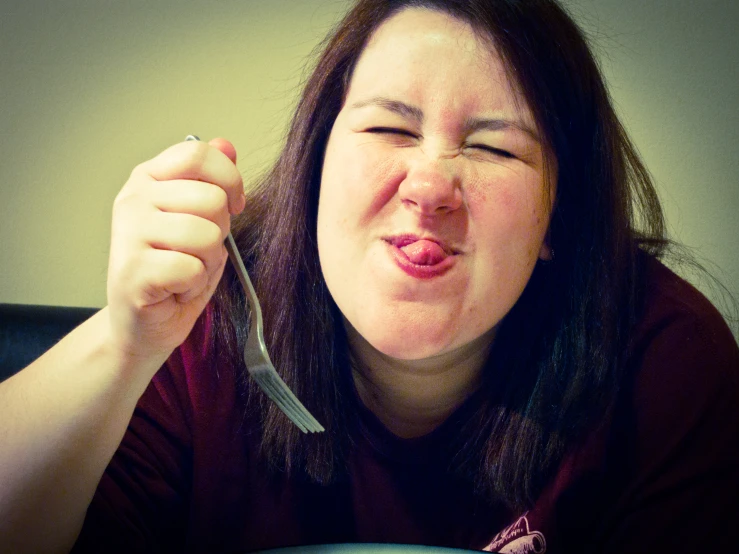 the woman is enjoying eating a bite out of her fork