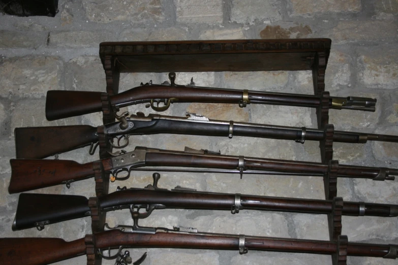 guns are on display behind a wall