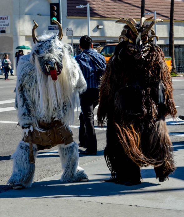 a couple of giant horned men walking down a street