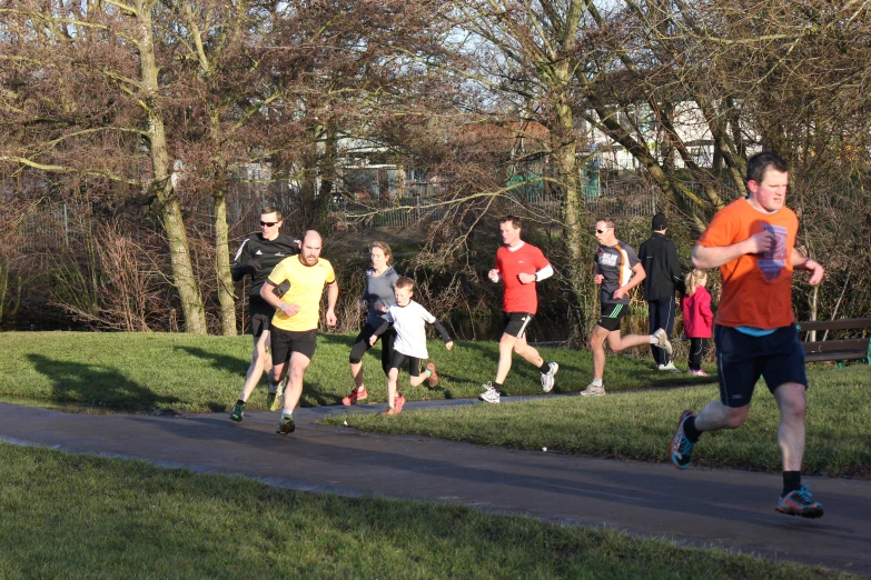 a group of men and children are running on a street