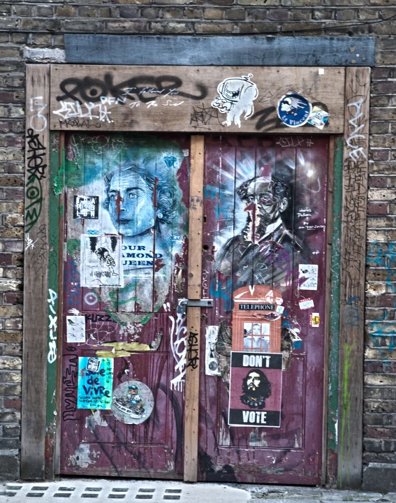 two wooden doors covered in graffiti, some are open