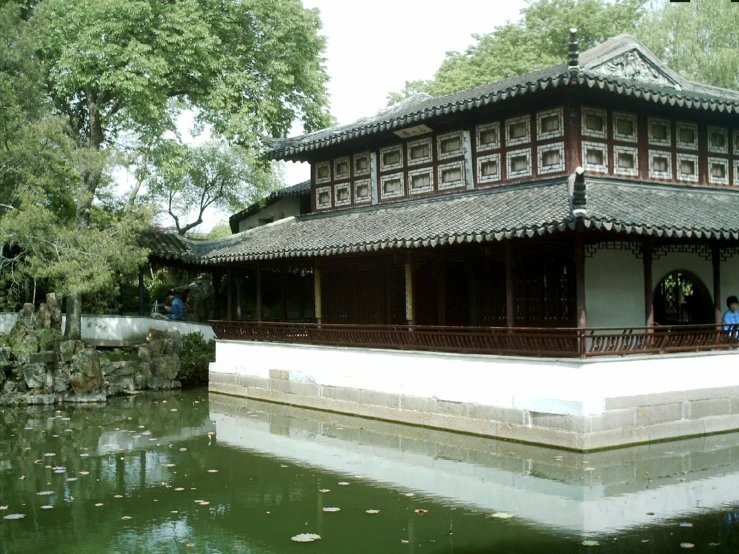 two men sitting at a chinese building by water