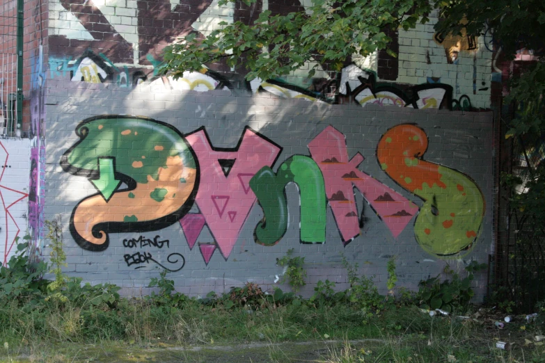 a wall with a number three spray painted in green, pink and purple
