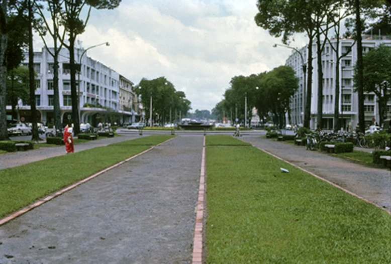 the city sidewalk with two lane ends and a long grass area near the side of a road